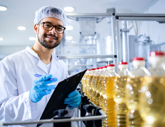 Trabajador verificando la producción de botellas de vinagre en una fabrica